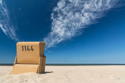 Hooded beach chair against blue sky