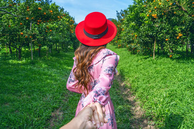 Rear view of woman standing on grassy field