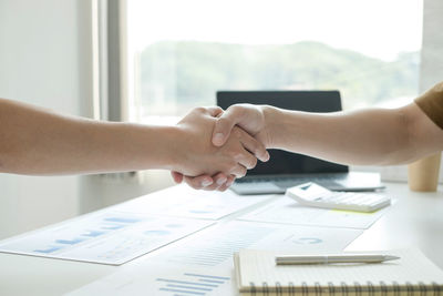 Cropped hands of business colleagues working at office