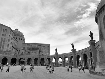 Group of people in front of historical building against sky