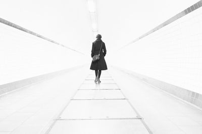 Rear view of woman walking on road