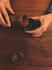 Hand holding coffee cup on table