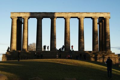 People in front of built structure against clear sky