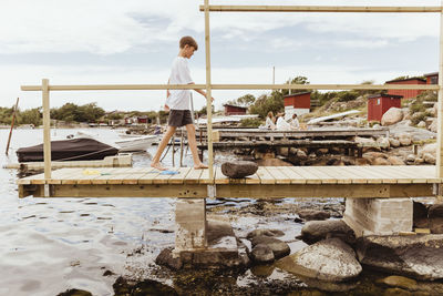 Pre-adolescent boy walking on jetty at marina