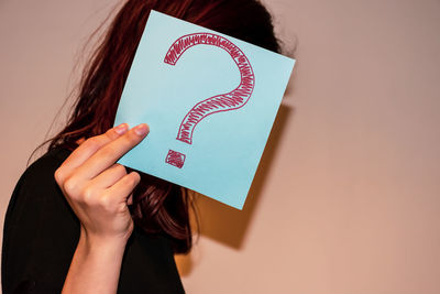 Midsection of woman holding heart shape text on paper