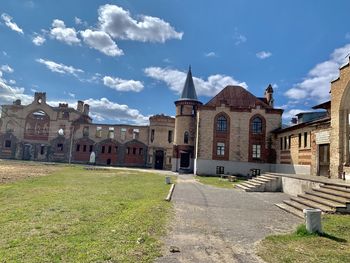 Houses by buildings against sky