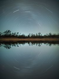 Scenic view of reflection of trees in water at night