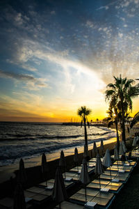 A colourful sunset scene of empty sun loungers on a beach in marbella, spain