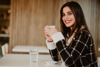 Portrait of a young woman drinking glass