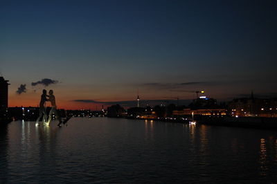 Molecule man sculpture on spree river at sunset