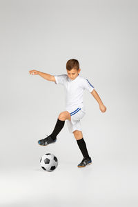 Man holding soccer ball against white background