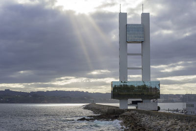 Built structure on beach by sea against sky