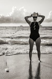 Full length portrait of woman standing at beach