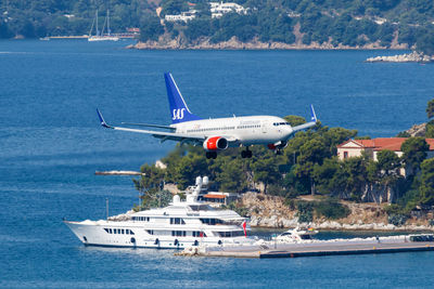 Airplane flying over sea against sky