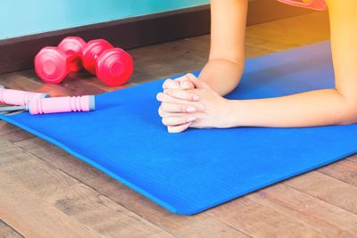 Cropped image of woman hand doing plank exercise on mat