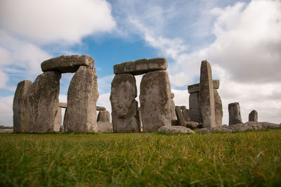 Historic stonehenge on field against sky