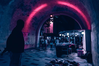 Rear view of silhouette people standing in illuminated building