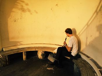 Side view of young man playing guitar