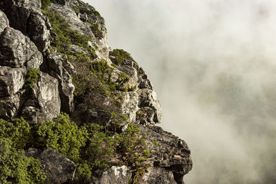 Low angle view of rock formation on mountain against sky