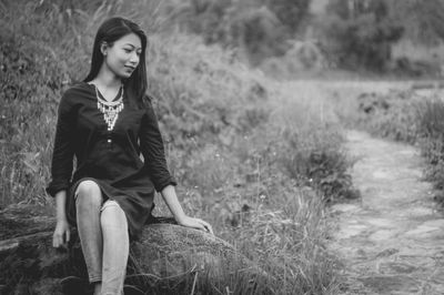 Smiling young woman sitting on field