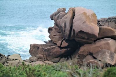 Rock formation on beach against sky