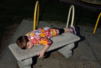 Boy lying on bench at playground