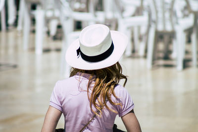 Rear view of woman wearing hat standing outdoors