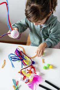 High angle view of boy holding toy on table