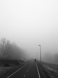 Diminishing perspective of road against sky during foggy weather
