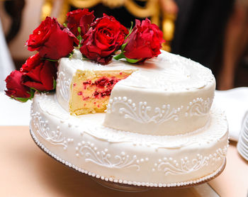 Close-up of roses over cake on table