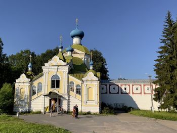 Church by building against clear blue sky