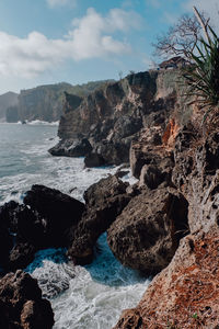 Rocks on beach against sky