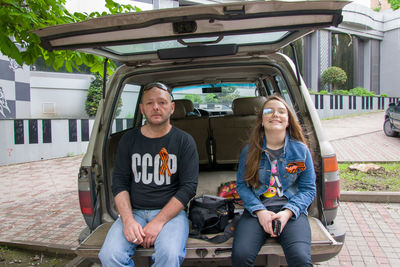 Portrait of a smiling young couple sitting outdoors