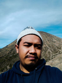 Portrait of young man against sky