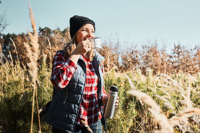 Woman taking break and relaxing with cup of coffee during summer trip. spending vacations