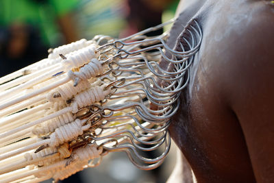 Close-up of hooks with rope pierced on man back