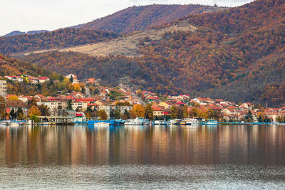 Scenic view of lake by buildings during autumn