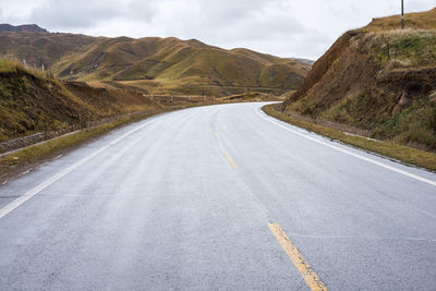 Road by mountain against sky