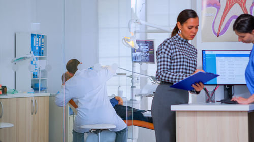 Rear view of female friends standing in laboratory