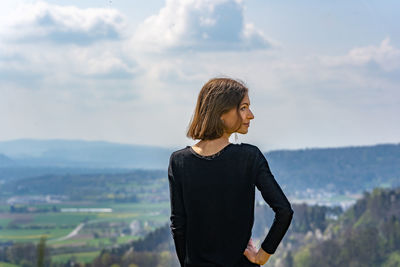 Side view of woman looking away against sky