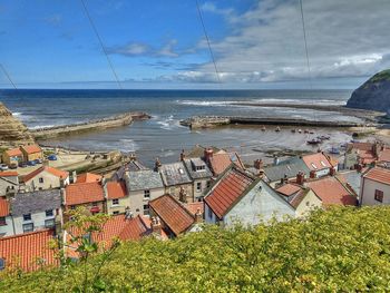 High angle view of sea and buildings against sky