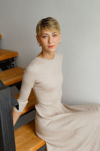 Portrait of young woman sitting on table at home