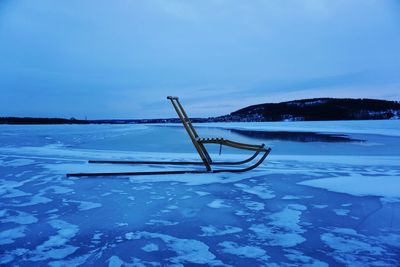 Scenic view of sled on ice against sky during winter