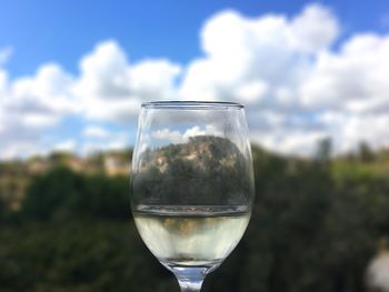 Close-up of wineglass against sky