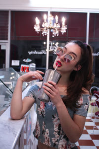 Portrait of young woman drinking milkshake