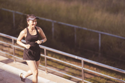 Full length of woman standing against railing