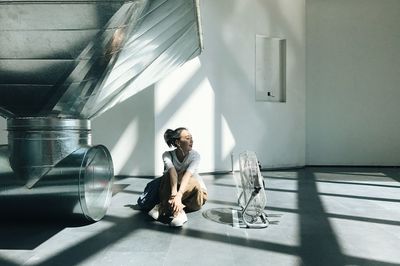 Full length of man sitting by window