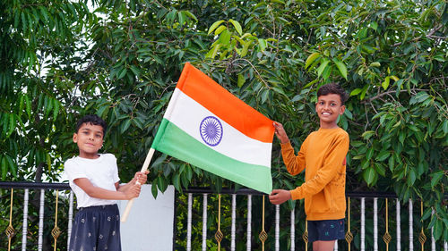 Two indian child celebrating independence or republic day, cute little indian child holding, waving 