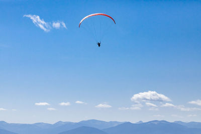 Low angle view of person paragliding against sky