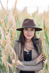 Portrait of smiling young woman standing against plants